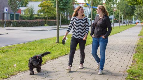 Twee vrouwen wandelen met een hond
